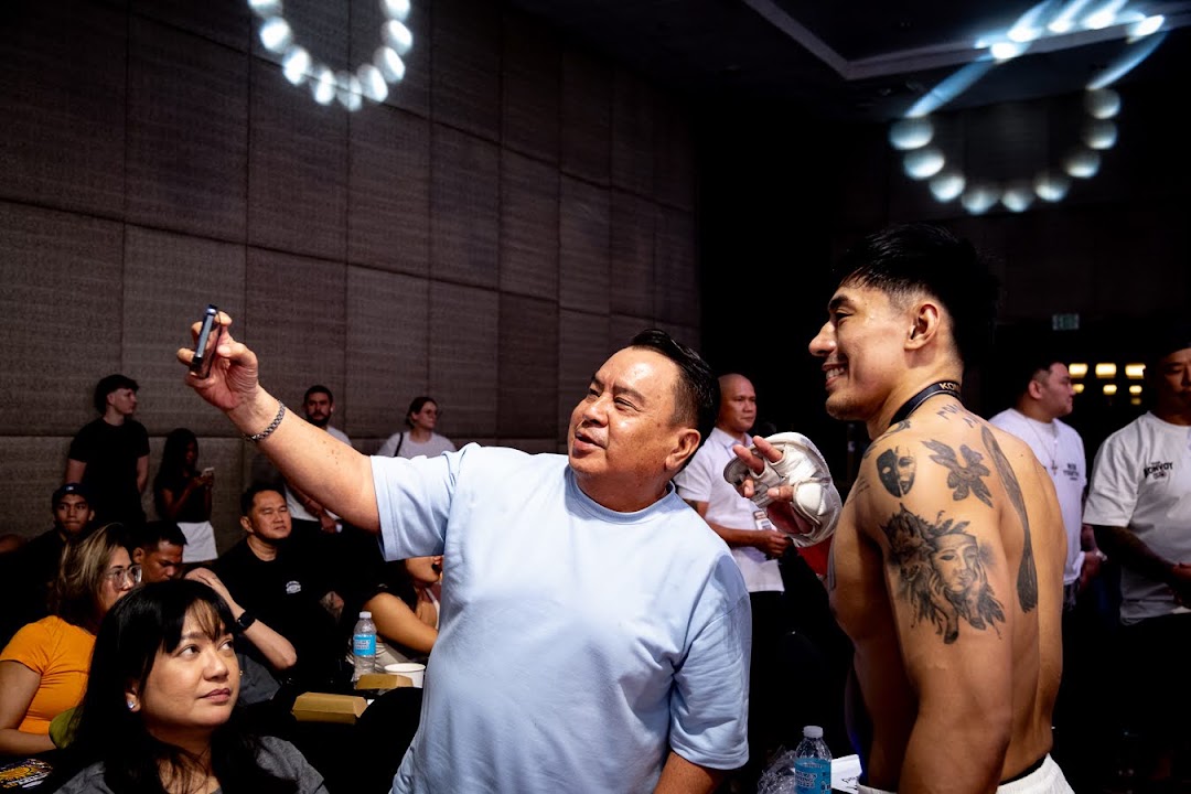 A Cebu fight fan takes a photo with a Konvoy MMA fighter after the event.