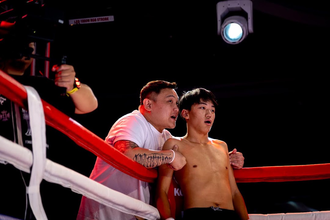 A corner coach gives instructions to an MMA fighter between rounds.