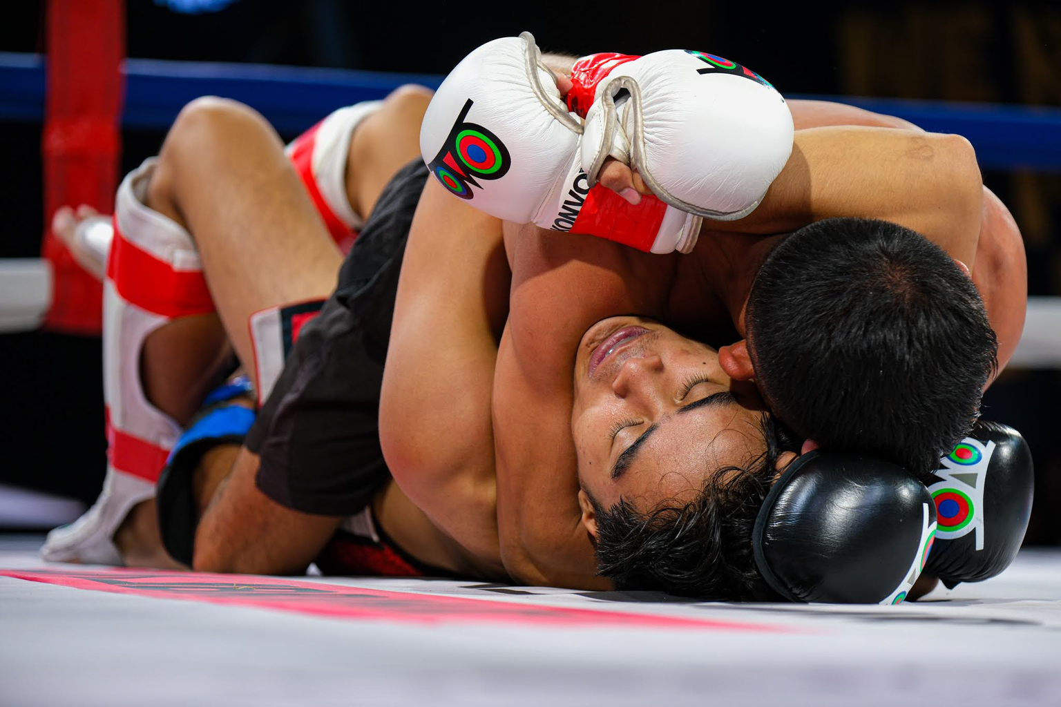 A fighter maintains top control over an opponent on the ring canvas at KONVOY 03.