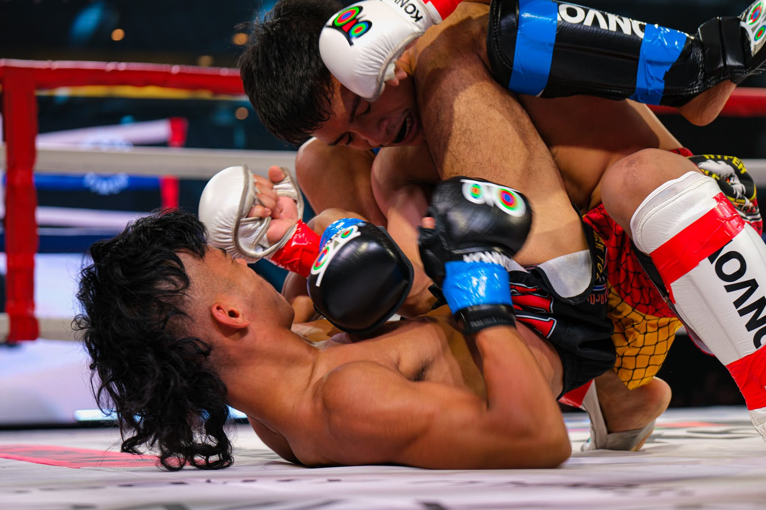 Two fighters shift position during a ground exchange in the ring at KONVOY 03.
